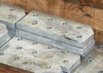 CNC drilled plates of aluminium stacked on top of another